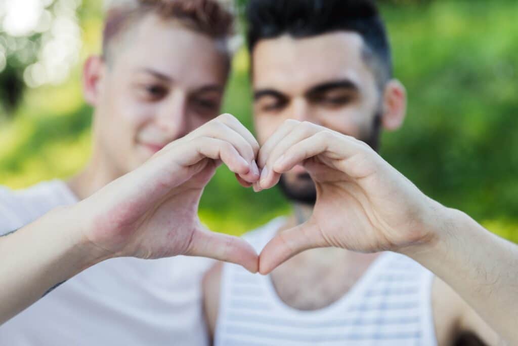 Two guys making a love heart with their hands